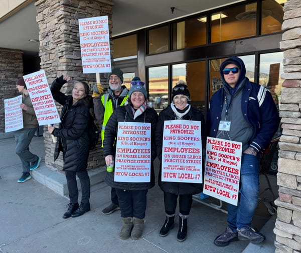 UFCW Local 7 workers stand outside a King Soopers store with signs that read "Please do not patronize."