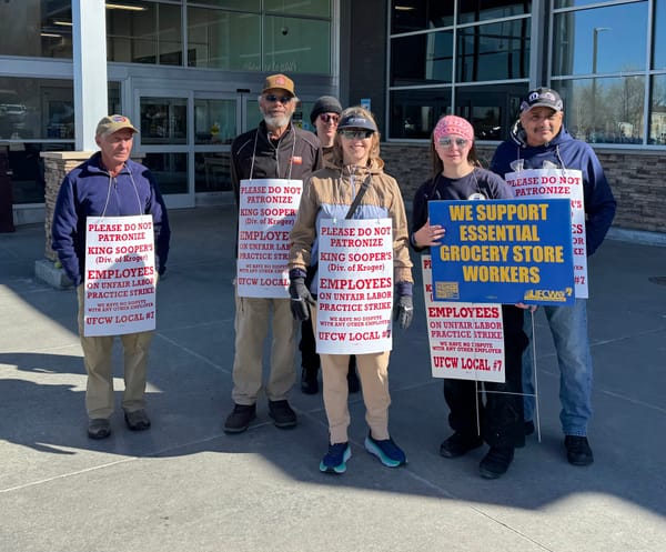 Workers stand outside the Table Mesa King Soopers holding signs that read "Please do not patronize".