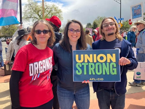 Alejandra, Nicole, and Shane (from UFCW) pose with a sign that reads "Union Strong AFL-CIO."