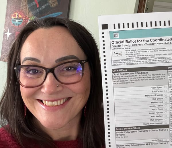 Nicole smiles while holding up her 2025 Boulder County ballot.